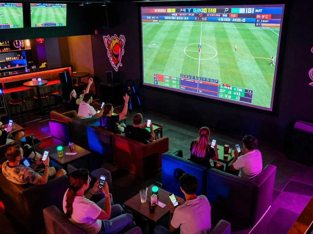 Engaged bettors in a lively sports bar placing wagers on go88 sports matches using smartphones.